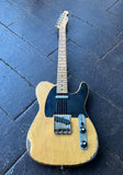 A Iconic Custom electric T-style electric guitar with a heavily worn, distressed natural wood finish, black pick guard \, maple neck and headstock resting on a dark wooden plank floor.