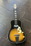Kay Acoustic guitar with a sunburst finish on a dark wooden floor
