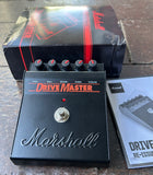 black Marshall Drive Master guitar effects pedal with packaging on a wooden surface