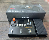 black Nux MG-400 guitar effects pedal  with six knob controls on a wooden surface