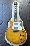 A Rock n Roll relics double cut electric guitar, electric guitar with a natural lemon burst flame-top finish and white pickguard, resting inside a white hard case on a dark wooden floor.