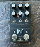 Walrus Audio R1 High Fidelity Staged Reverb guitar effects pedal with black body, silver knobs, and footswitches, photographed from above on a textured stone surface.